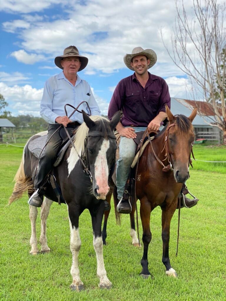 Richard Drew on black-and-white mare and James Salerno on bay mare, smiling on horseback in Salerno Stud paddock.